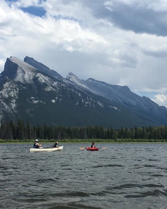 A beautiful view of Vermilion Lakes with two people canoeing 