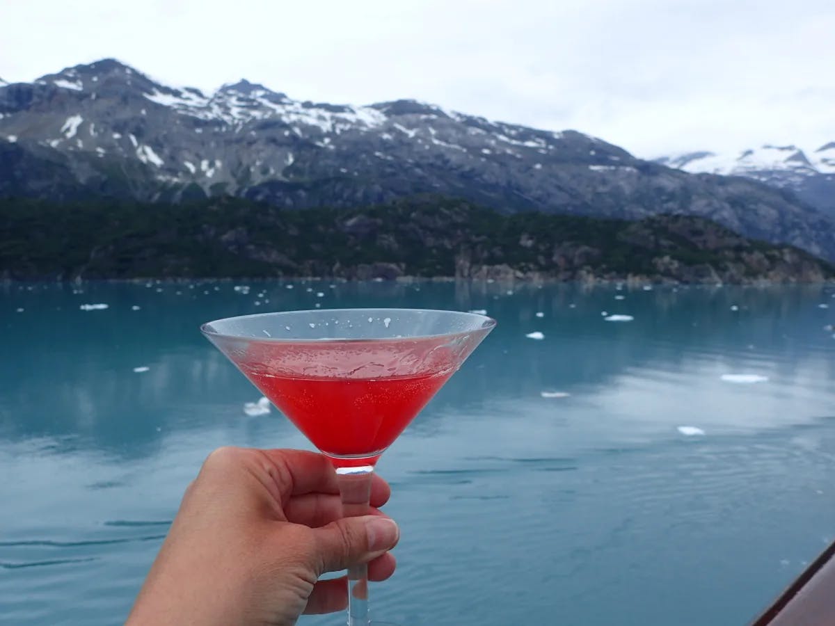 a-person-holding-drink-alaska-travel-guide