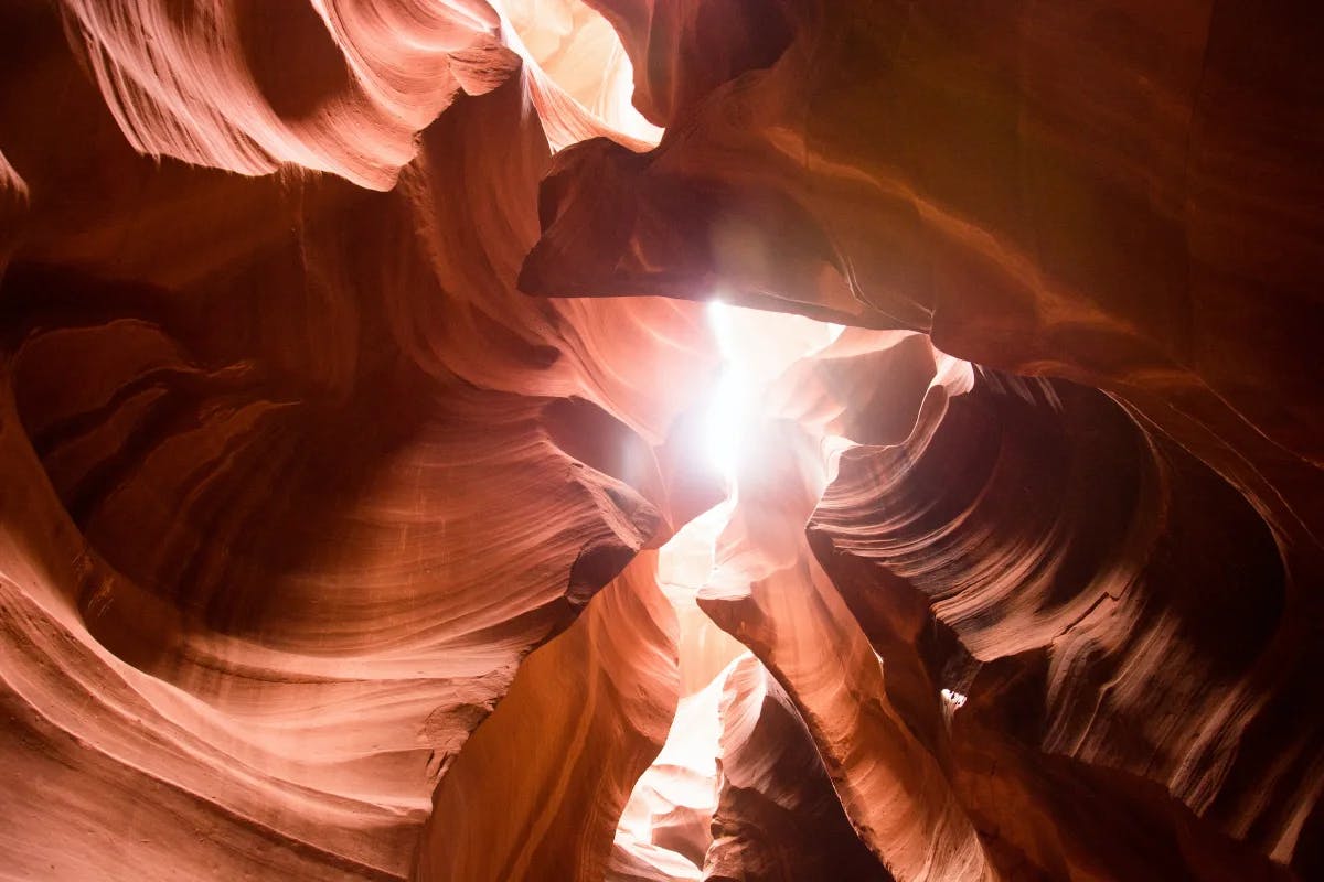 Antelope Canyon, a slot canyon in Arizona, is renowned for its mesmerizing light beams, sculpted sandstone walls, and breathtaking natural beauty.