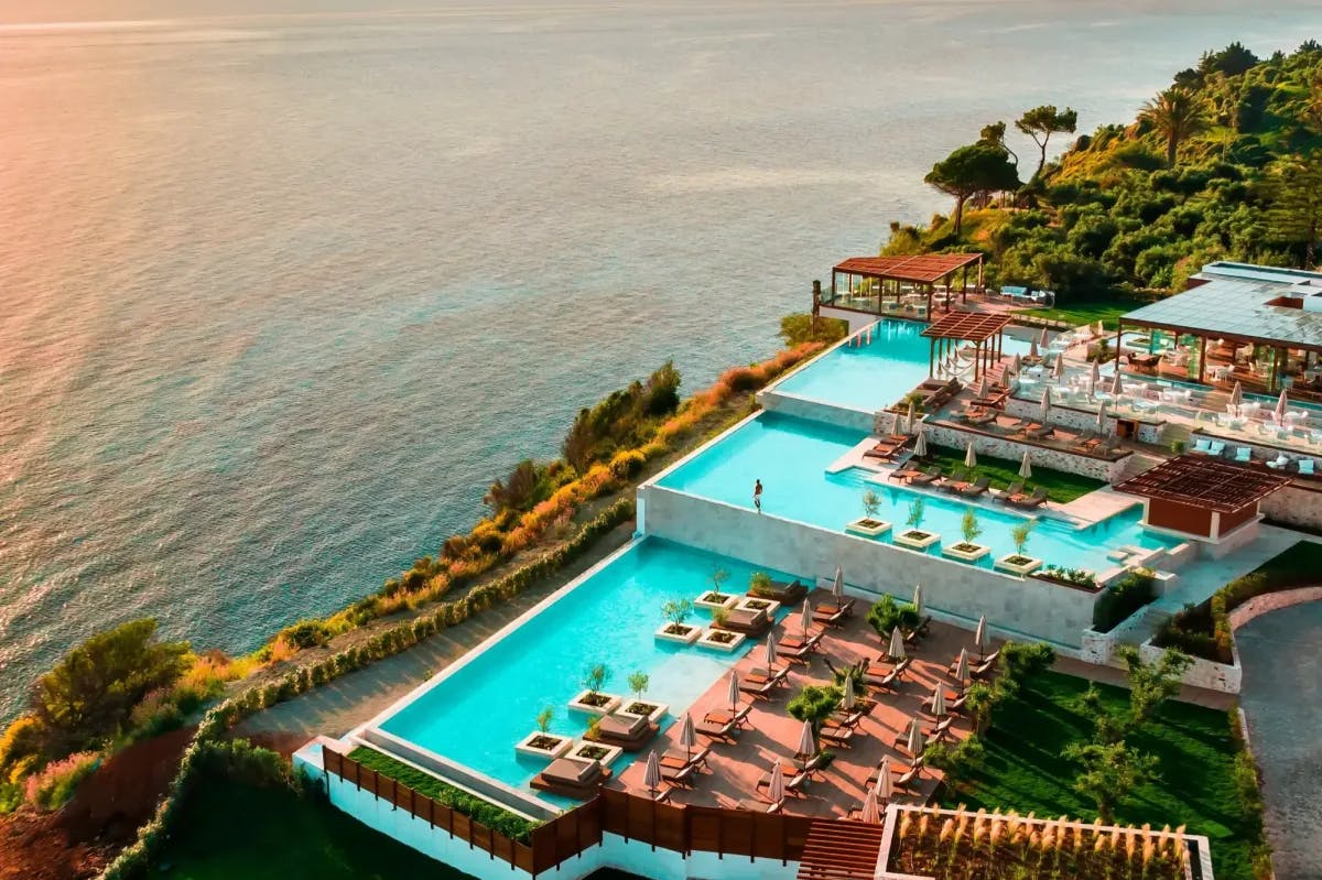 The stunning pool complex of Lesante Cape Resort & Villas overlooks Zakynthos picturesque shore at sunset