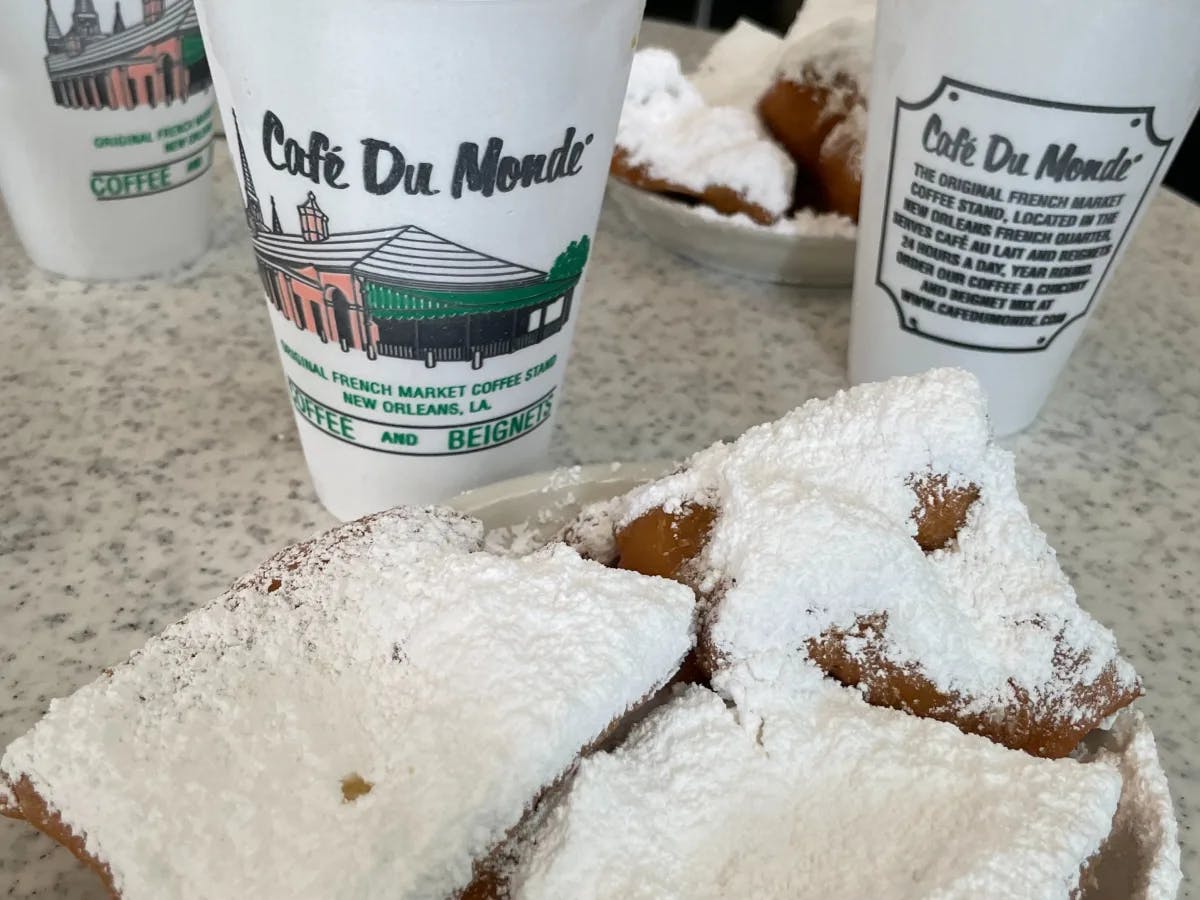 Beignets and cups that say Cafe du Monde