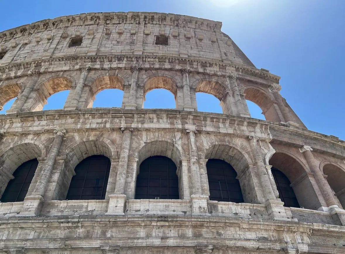 A low angled picture of the colosseum at daytime.