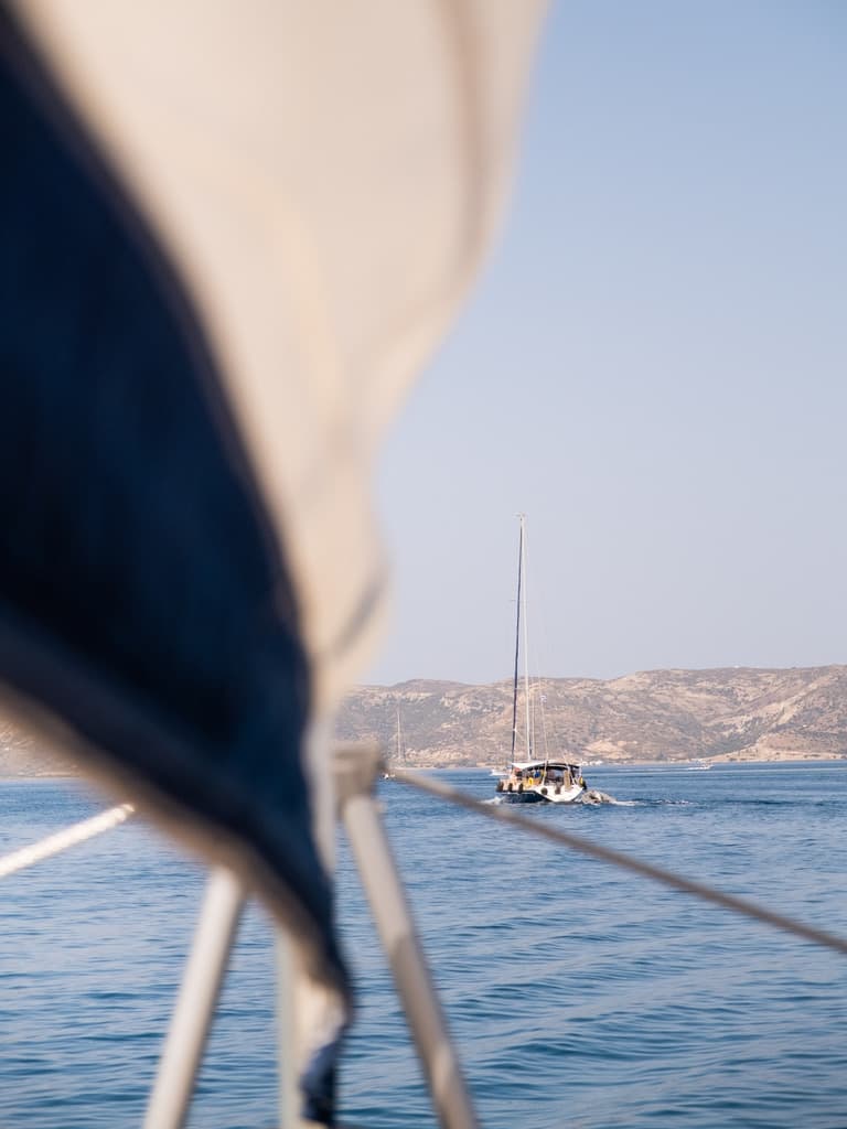 View of the sea from a sailboat with a mountainous coast line