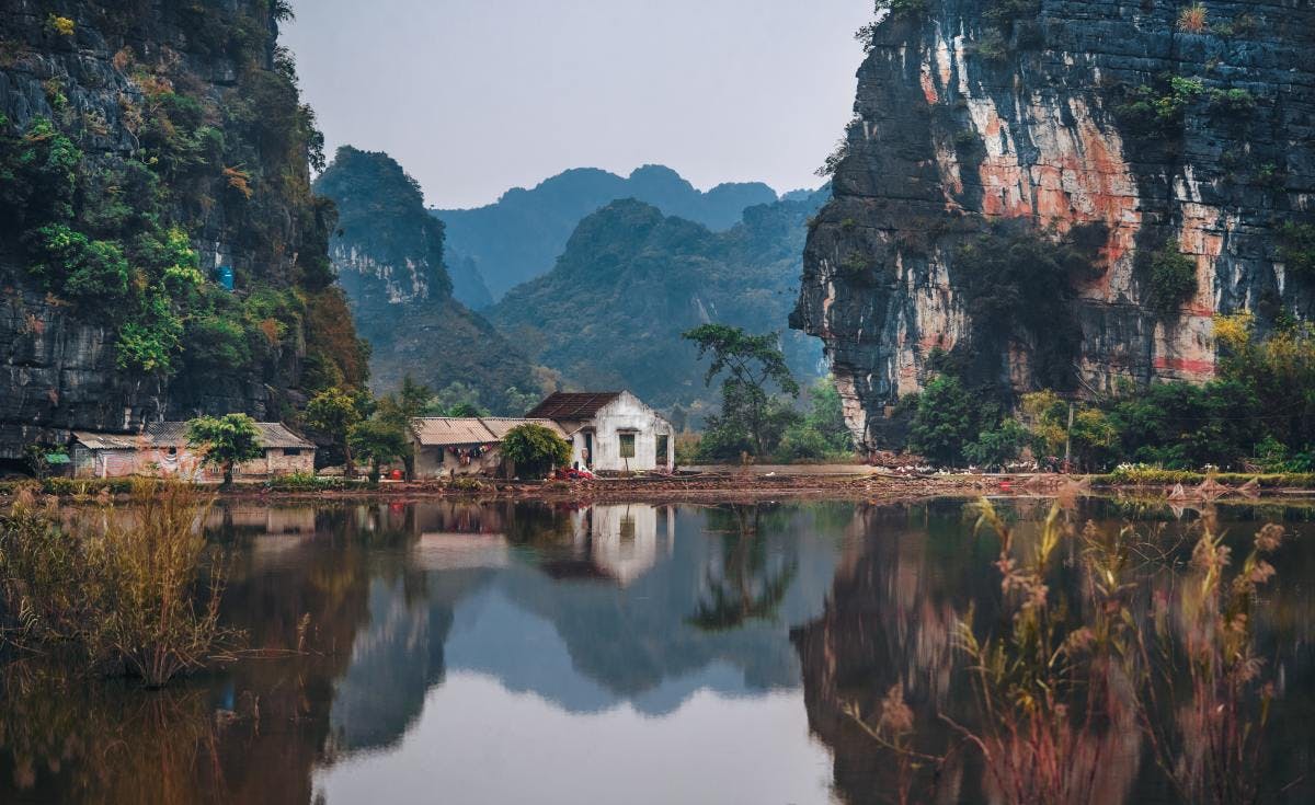 Clear lake reflecting large mountains in Vietnam. 