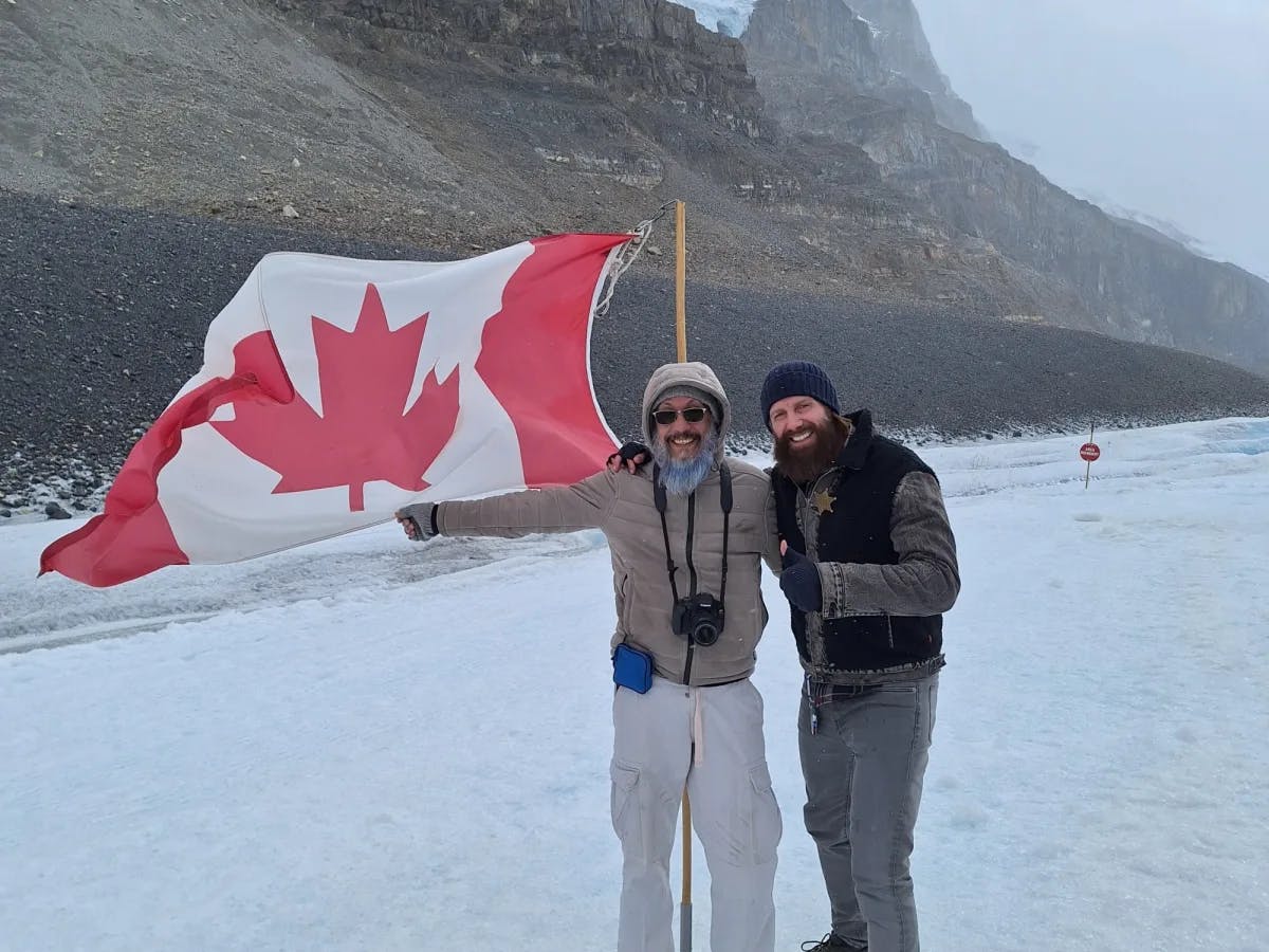 Two men on a glacier with Canadian flag.