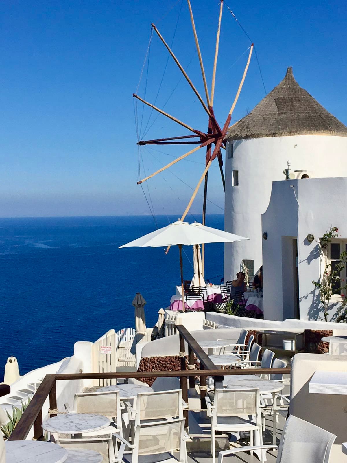 An outdoor sitting area on a balcony overseeing ocean.