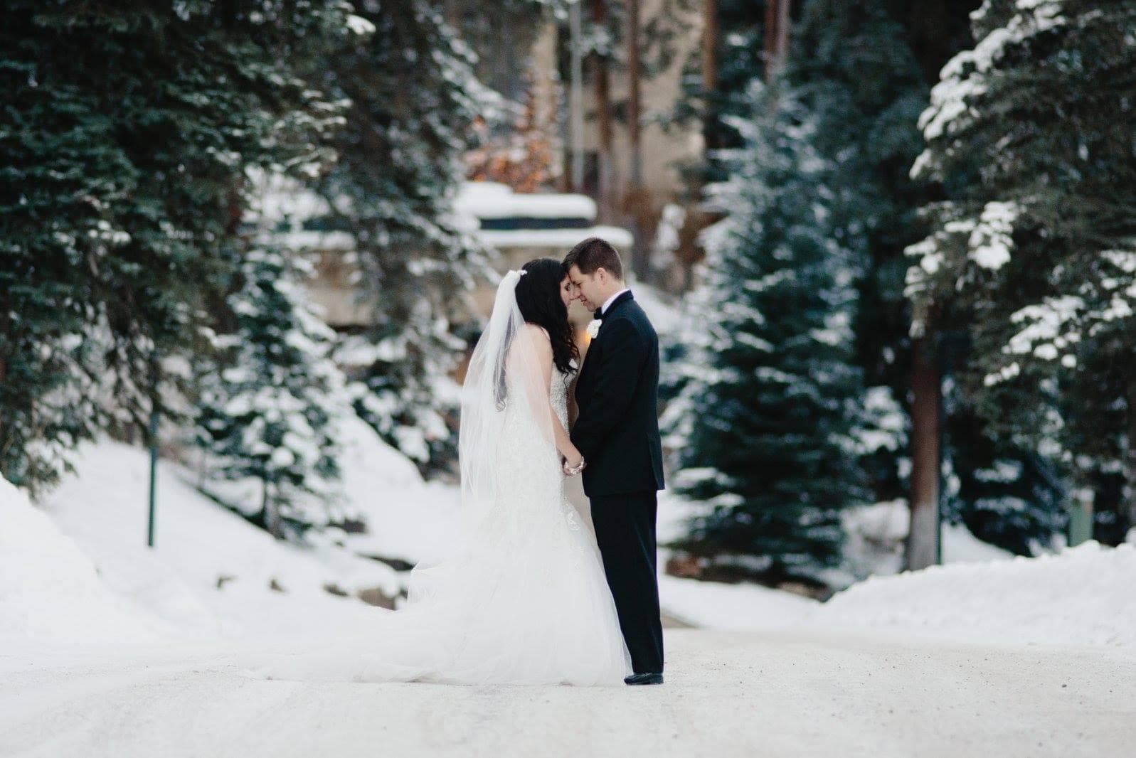 Couple in wedding dress posing on snow