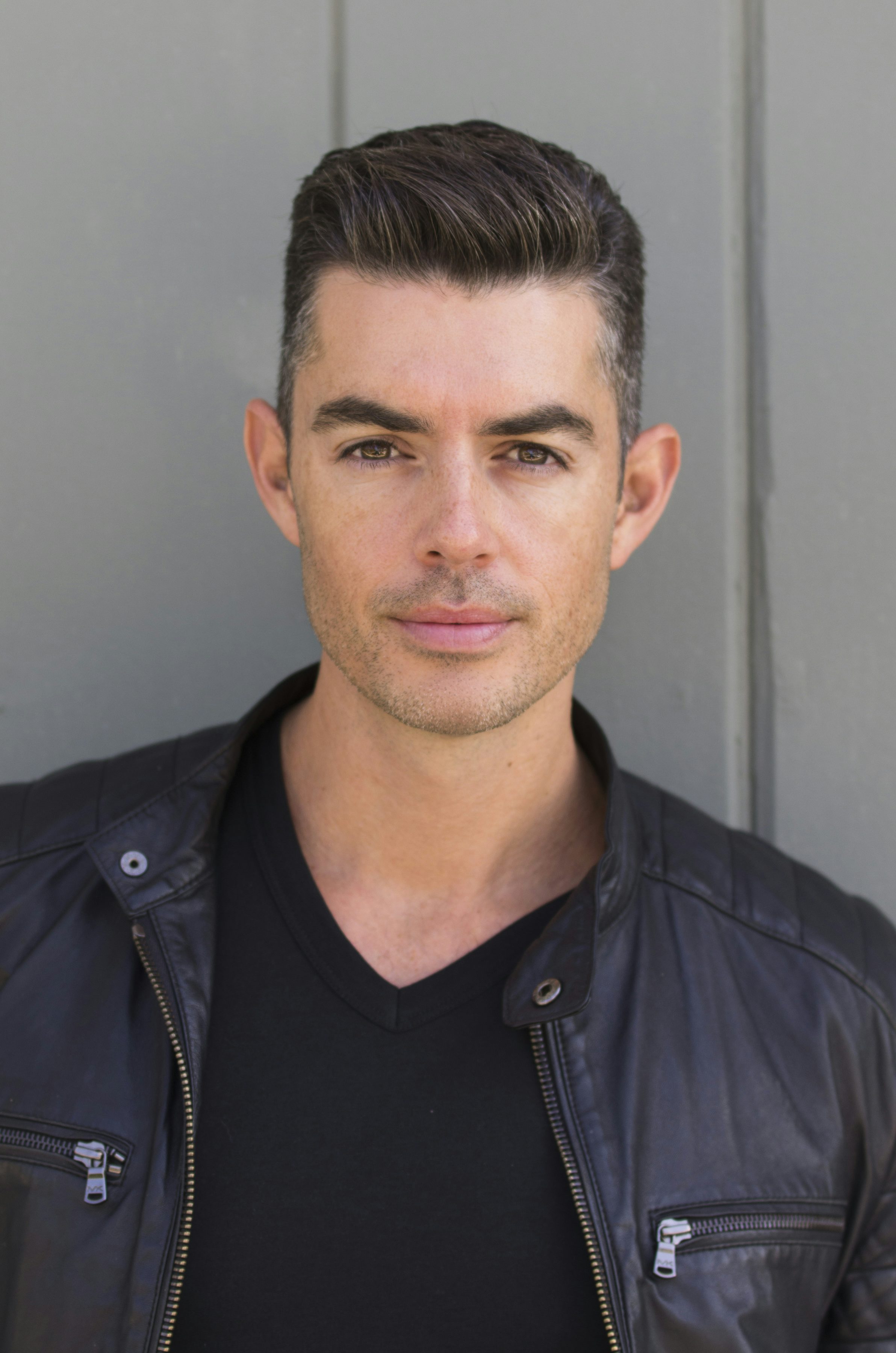travel advisor Jason Leon, with close-cropped gelled hair, wearing a black tee and a black leather jacket