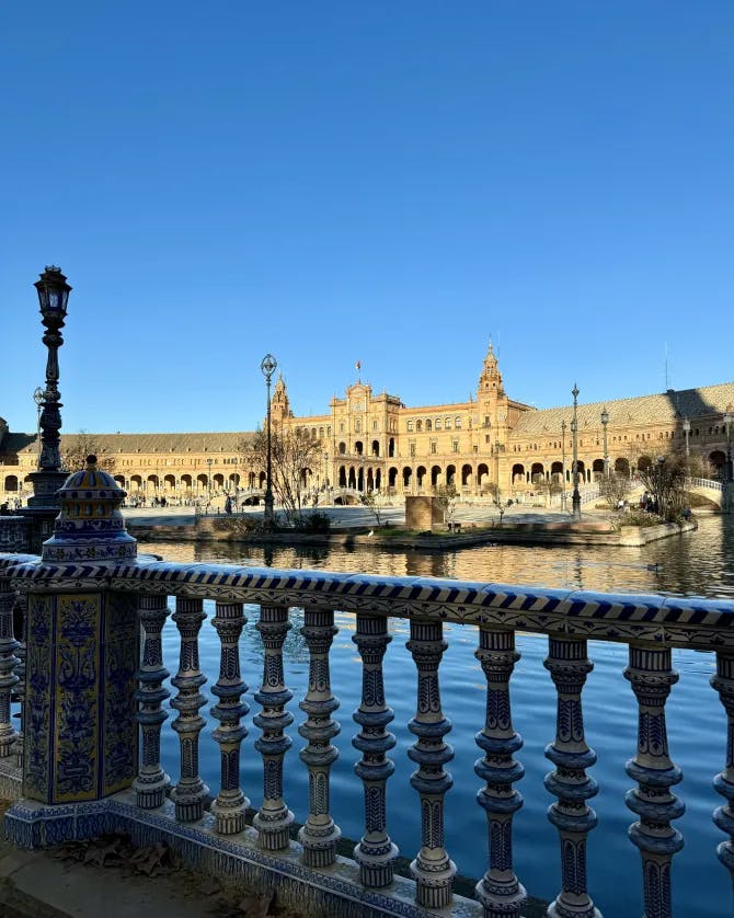 A view of Plaza de España with blue water and sunlit buildings in the background