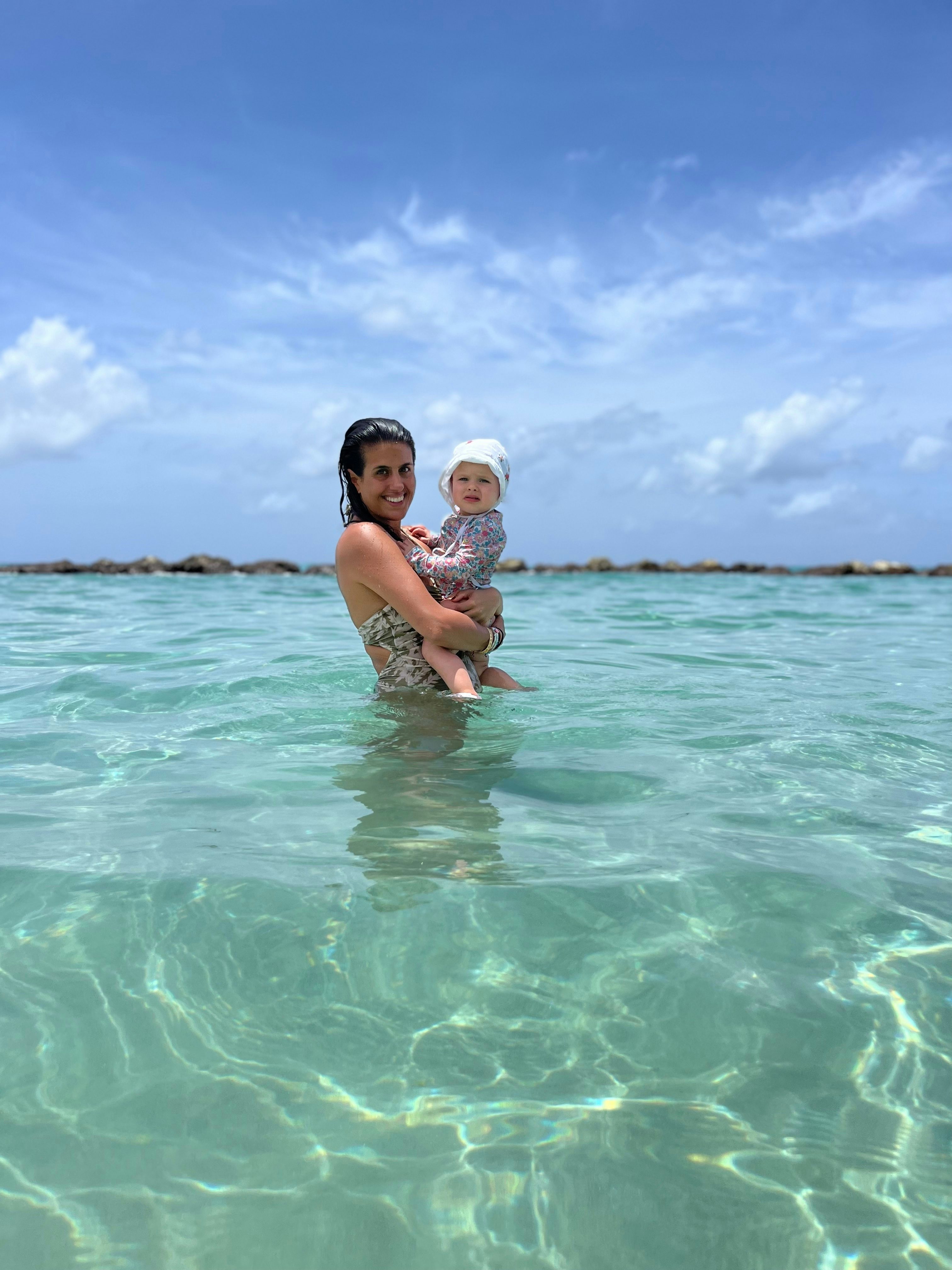 woman holding a baby in turquoise water