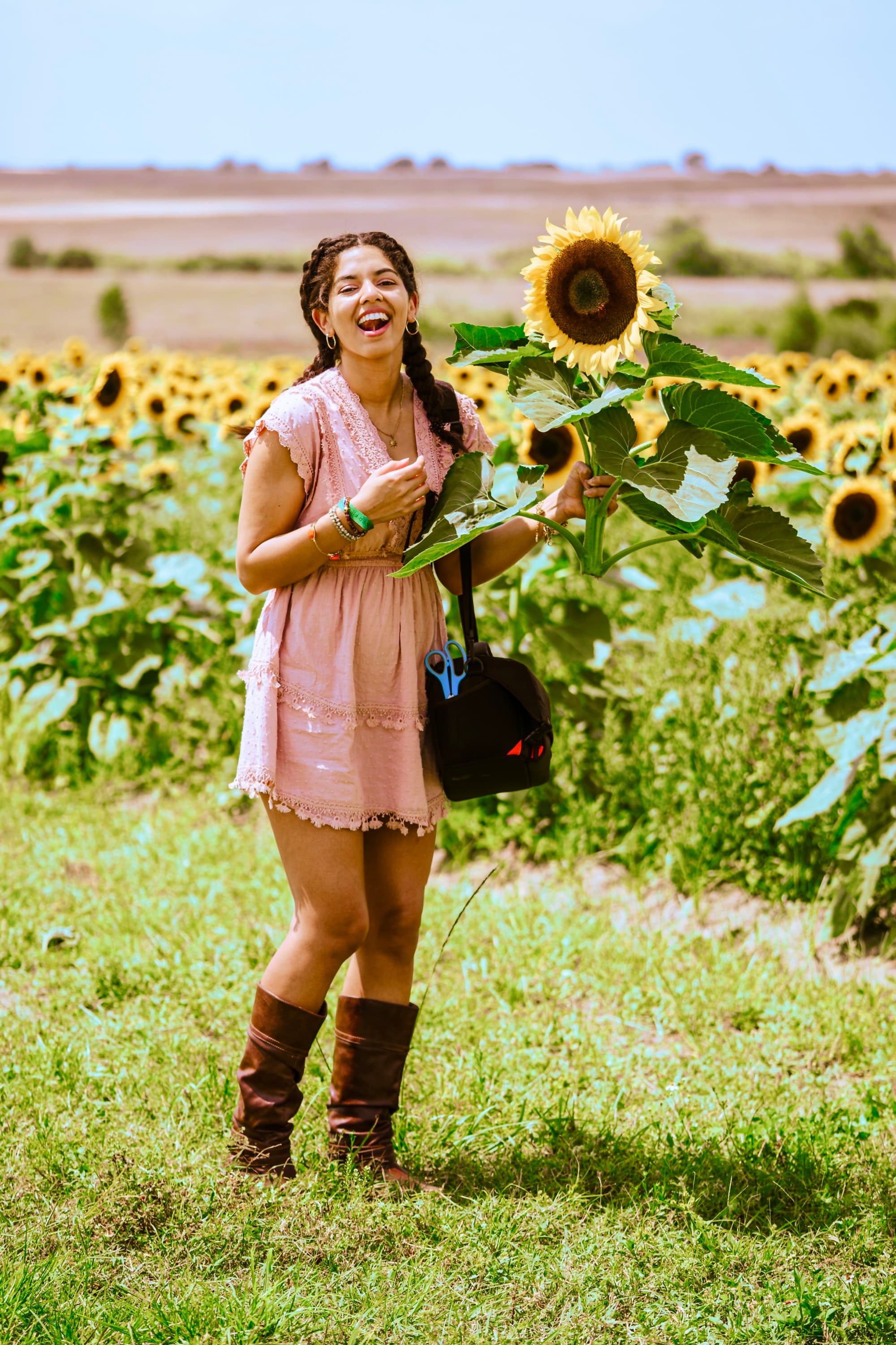 Travel advisor in pink dress holding a sun flower.