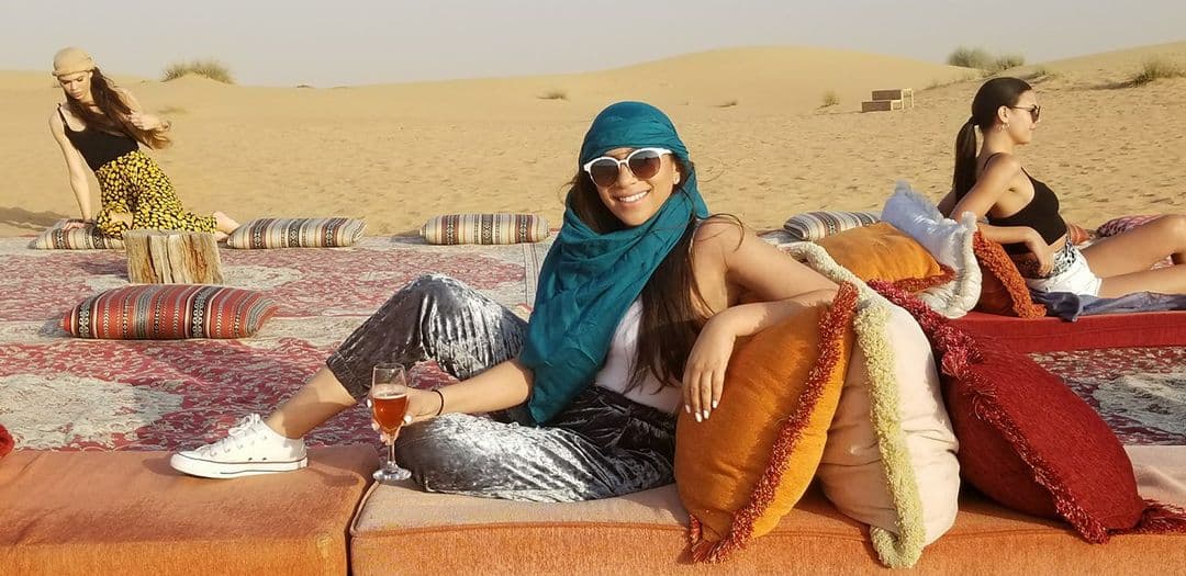 A woman sitting in the desert.