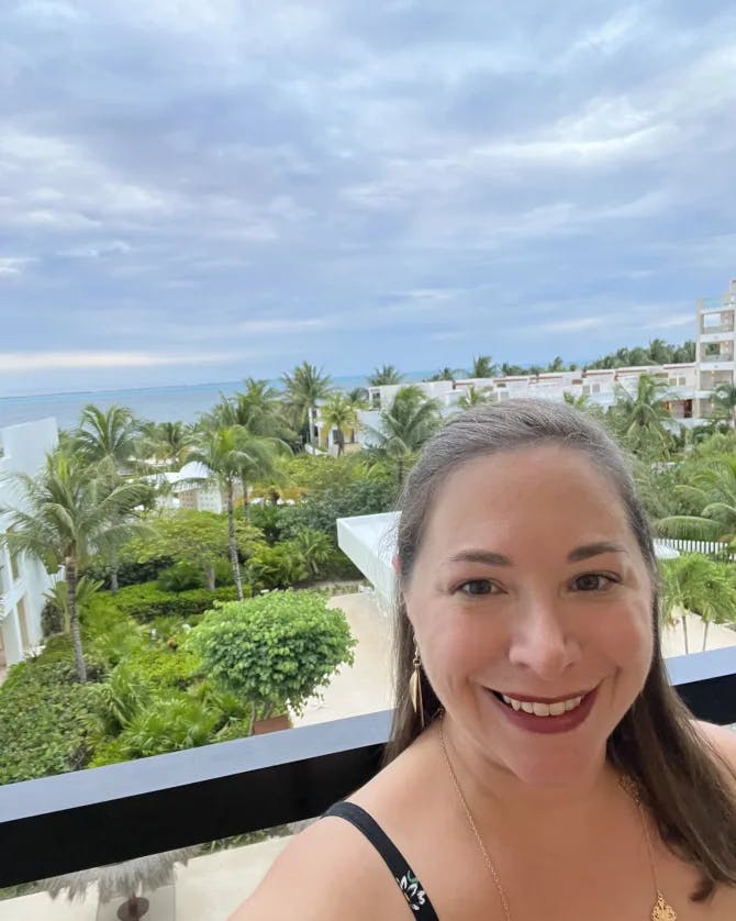 travel advisor stands on hotel balcony on the beach