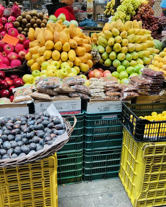 Fresh and colorful produce displayed in crates and baskets at a street market 