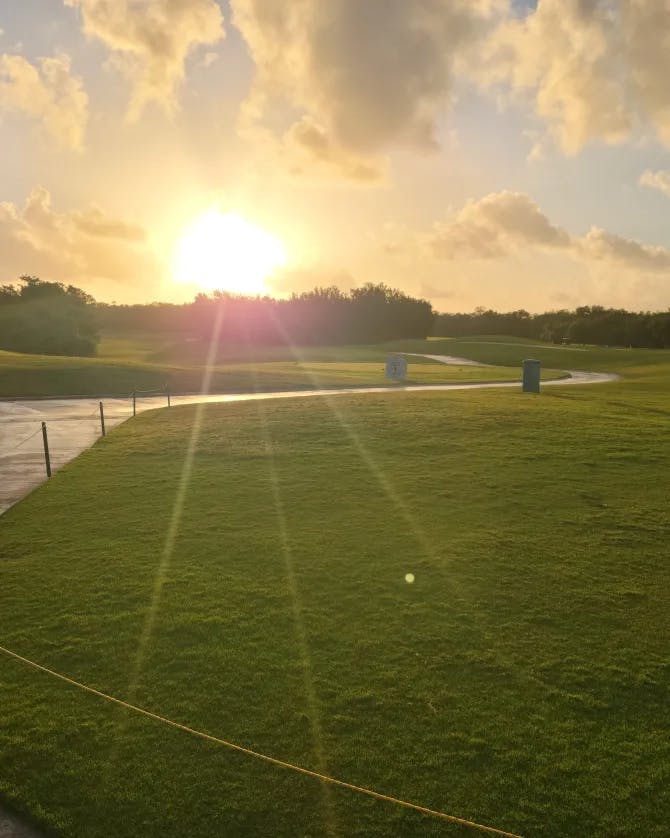 A beautiful view of a golf club at sunset with a pathway on the left