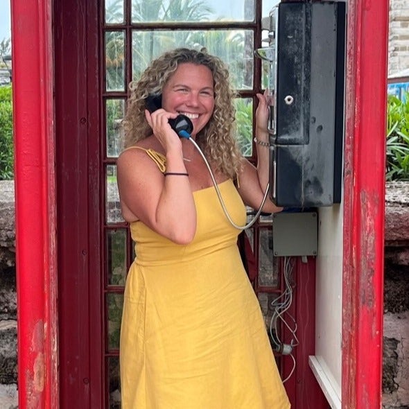 Travel Advisor Stephanie Lussier posing with a phone in yellow dress