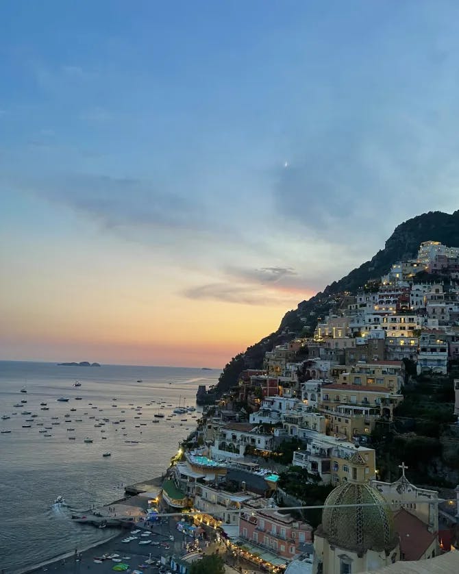 A picture of beautiful Positano at sunset with boats in the water