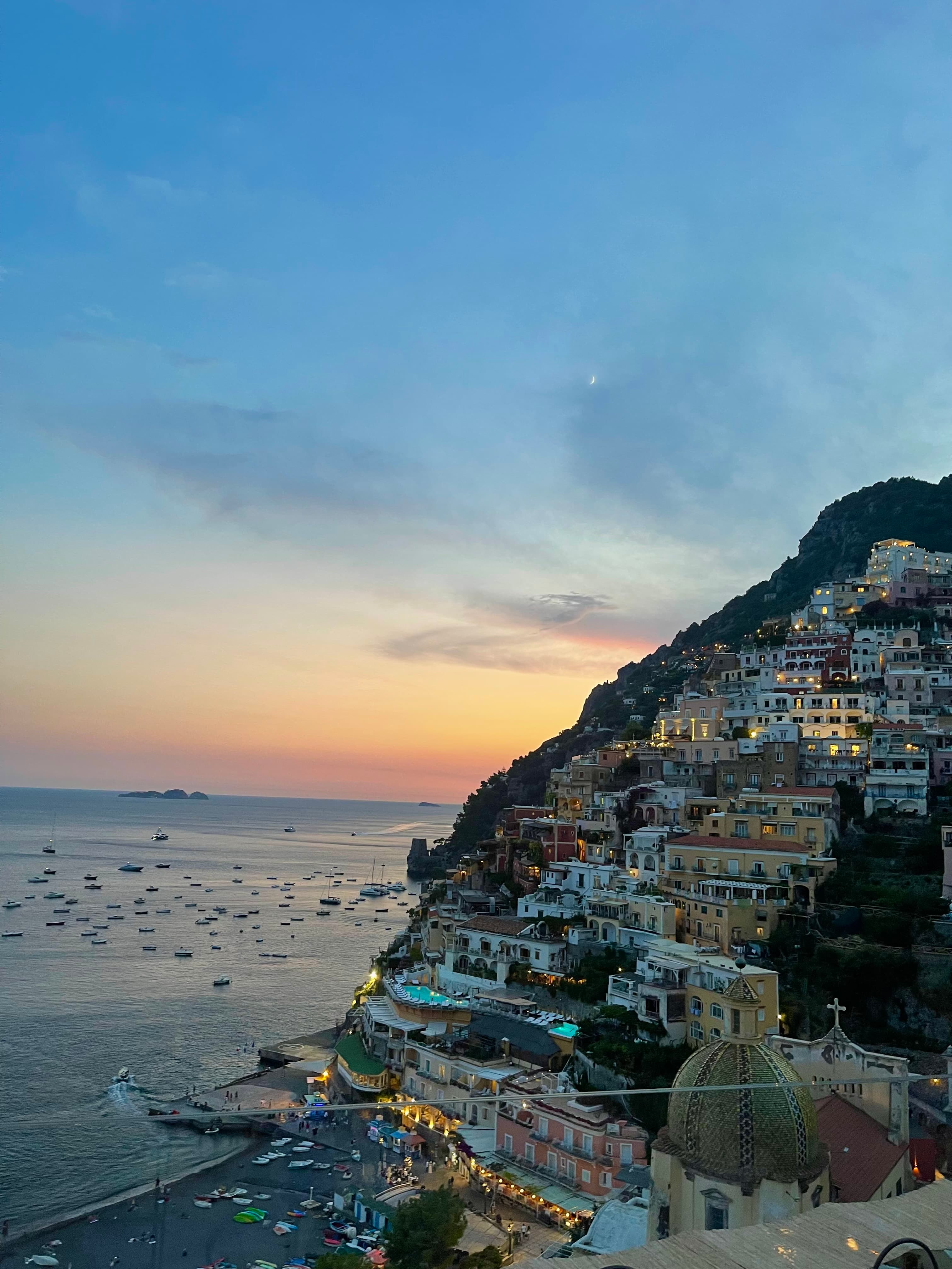 A picture of beautiful Positano at sunset with boats in the water