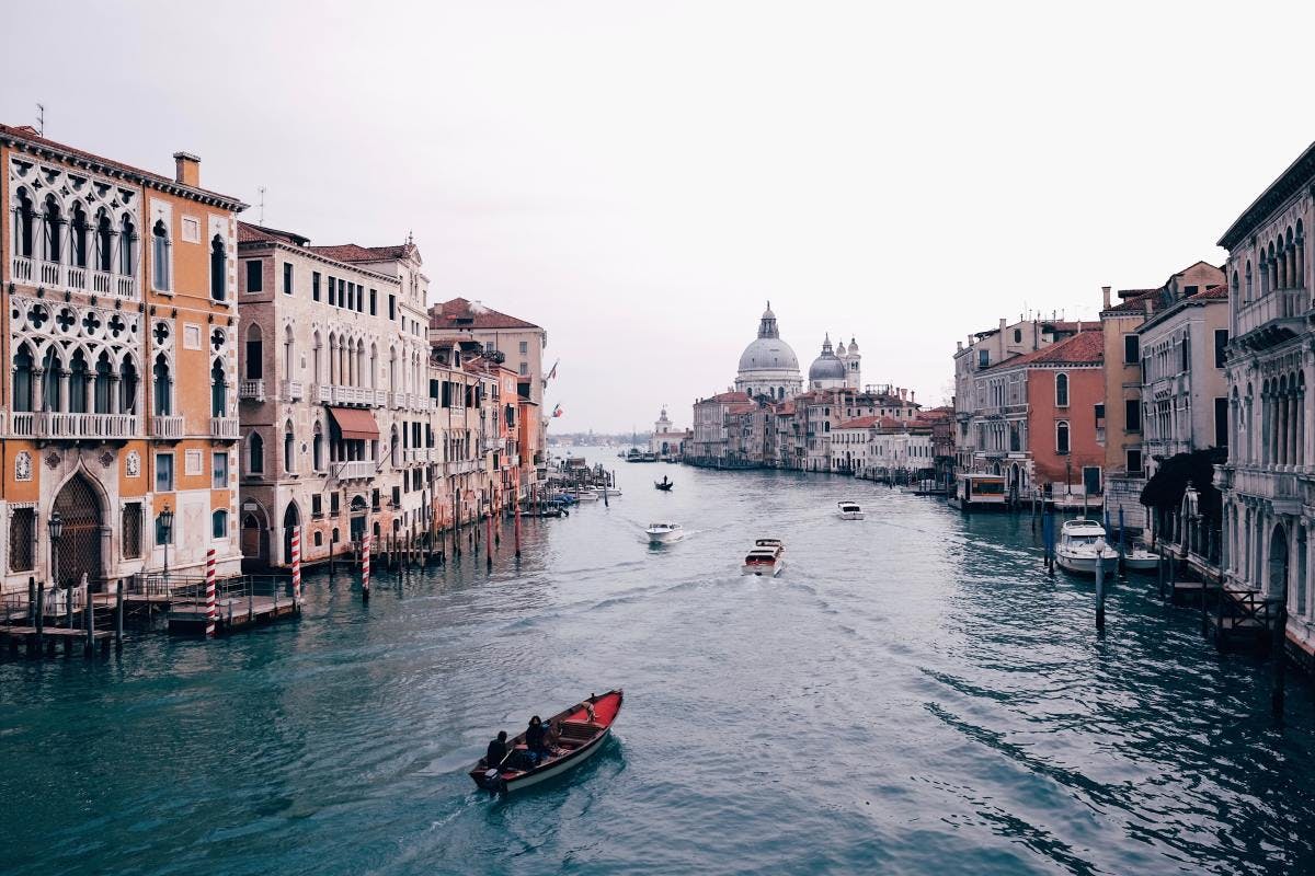 Gondolas rowing through canals of Venice, Italy. 