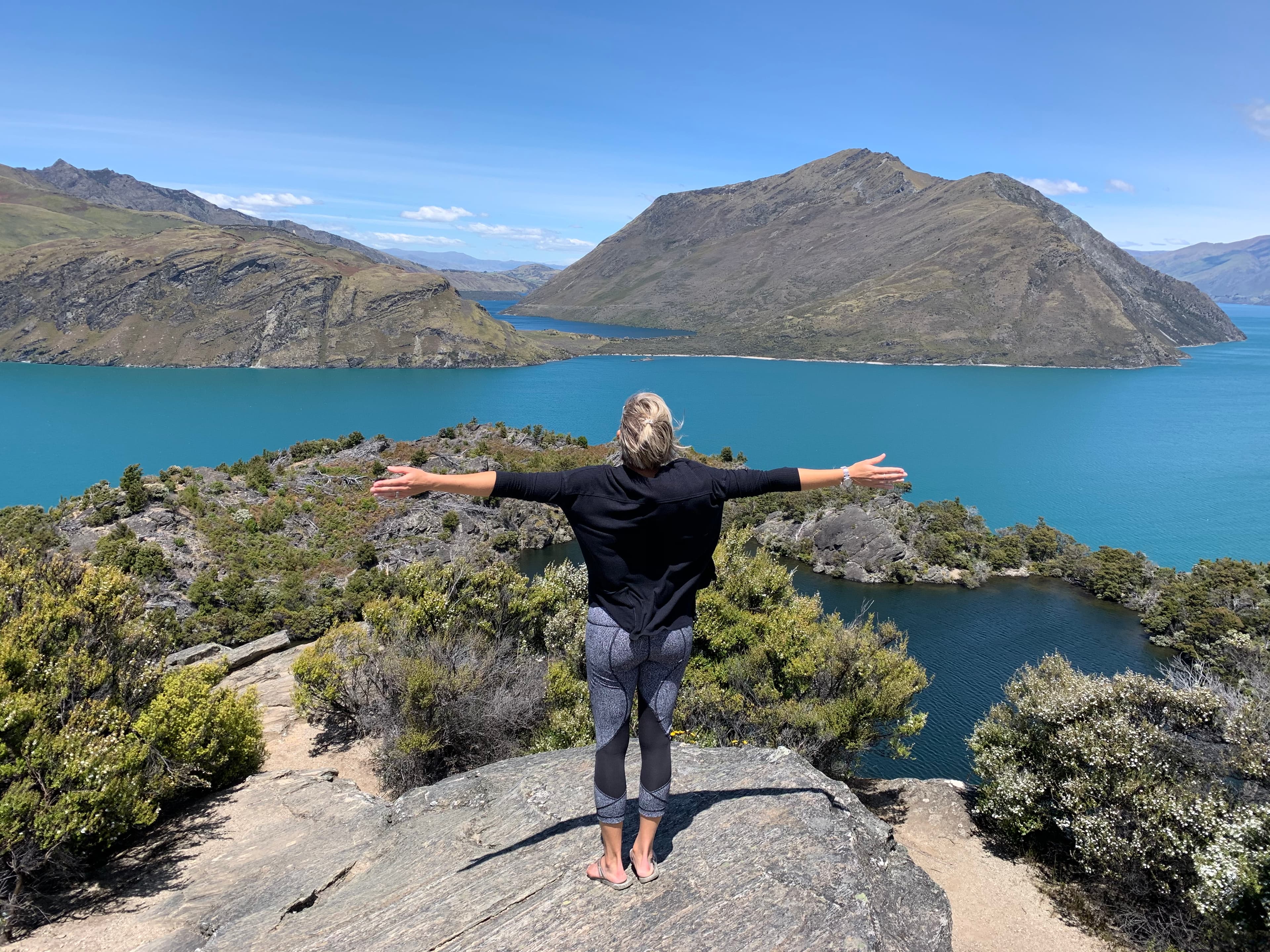 Travel advisor posing on a mountain top overlooking the sea side
