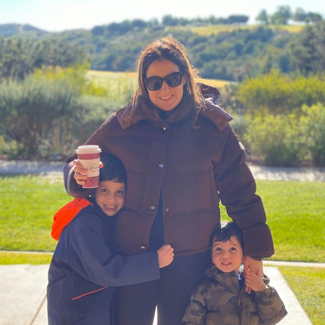 Travel Advisor Deana Karim poses with her kids in front of a mountainscape.