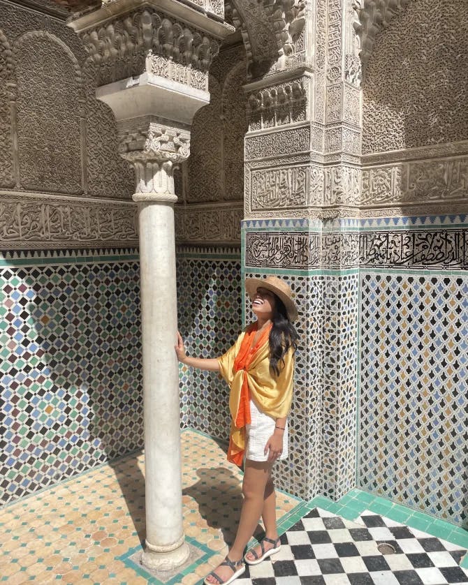 Cam posing on beautiful tiles with her hand on a pillar in Morocco