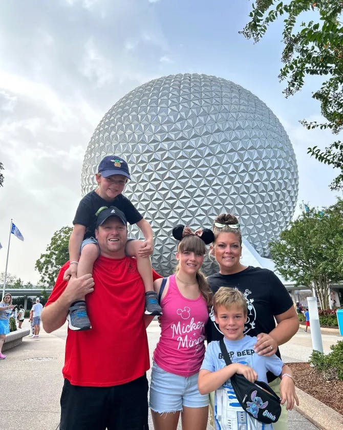 Travel advisor Michael with family standing in front of the large Epcot sphere