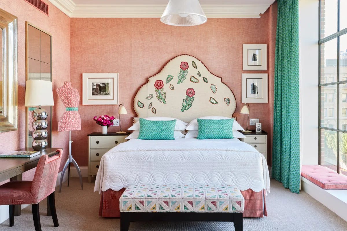 a posh bedroom decorated with pink decor and turquoise drapes