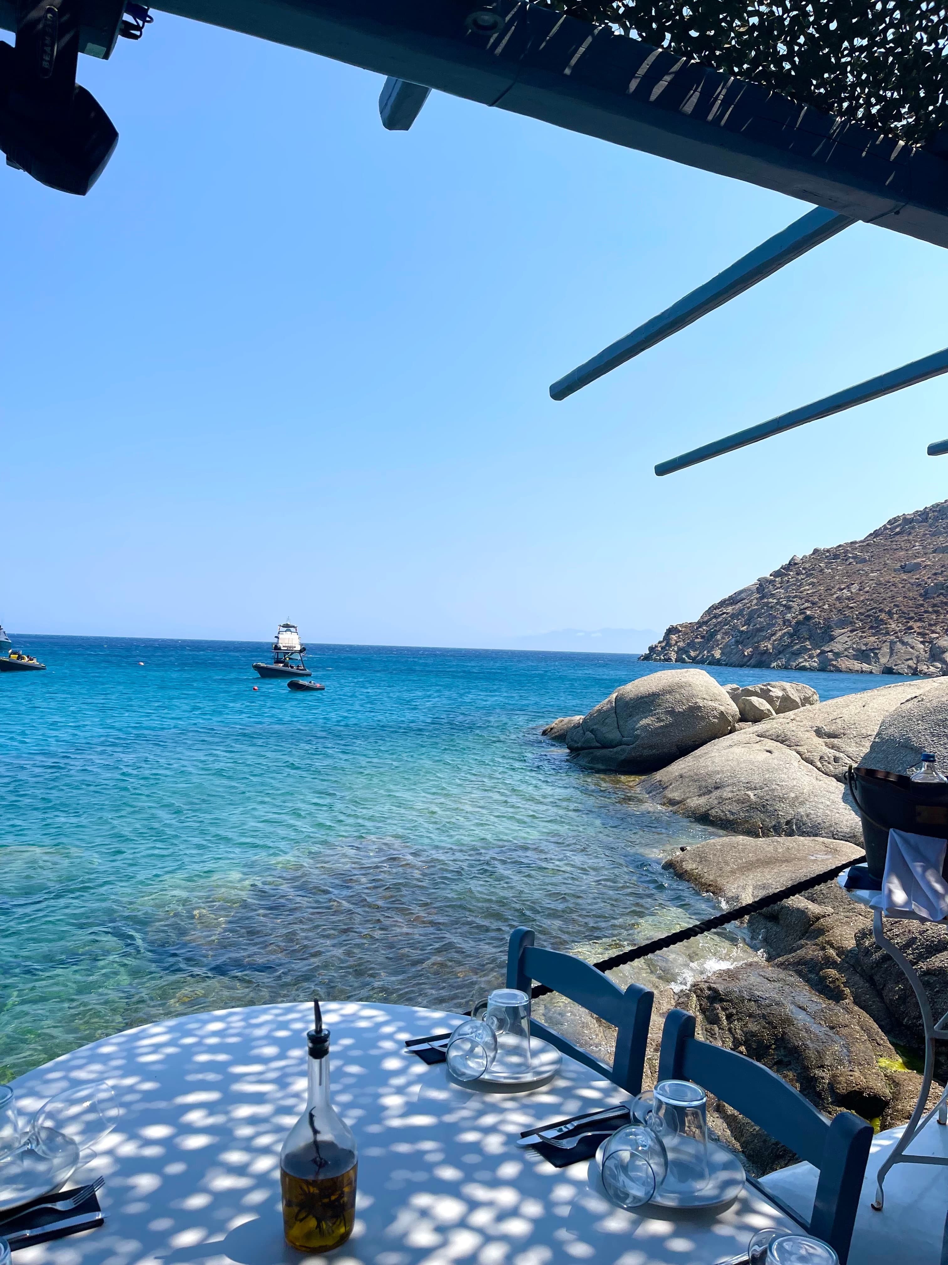 A picture of the crystal clear blue water from a white dining table
