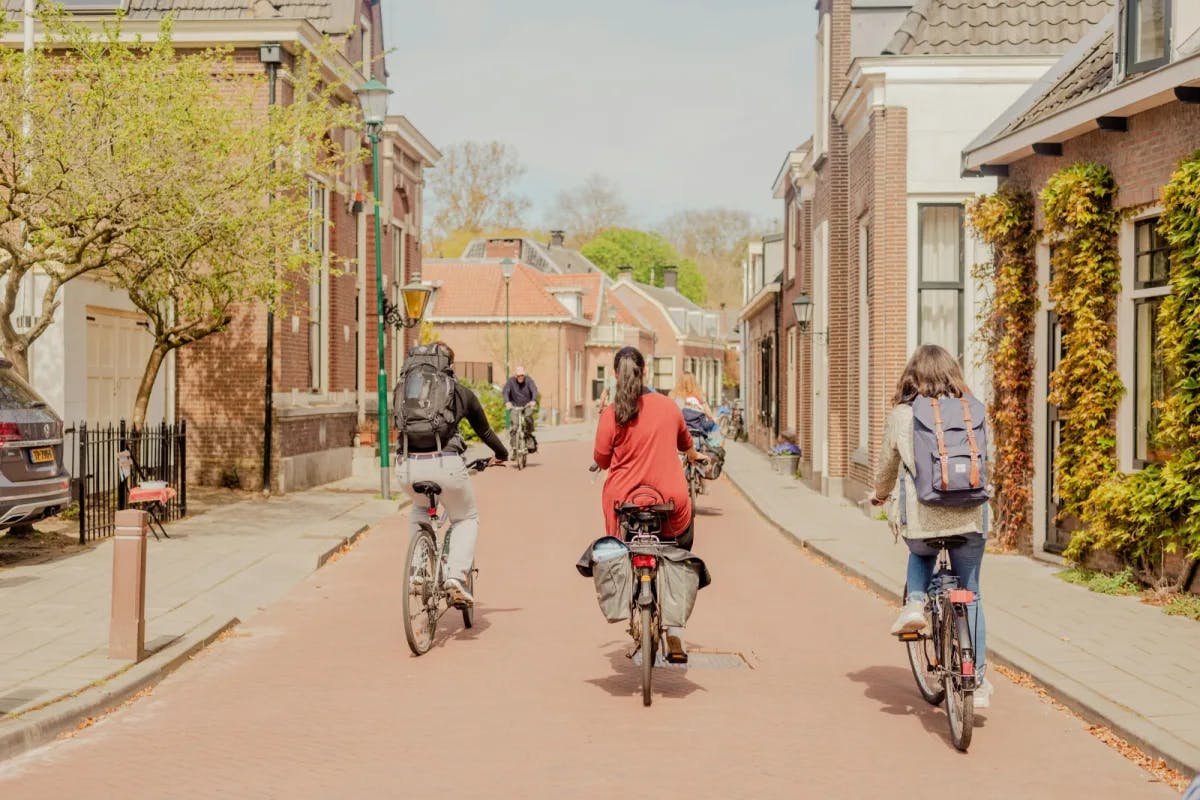 A few travelers ride bikes through red-stone streets in the Netherlands