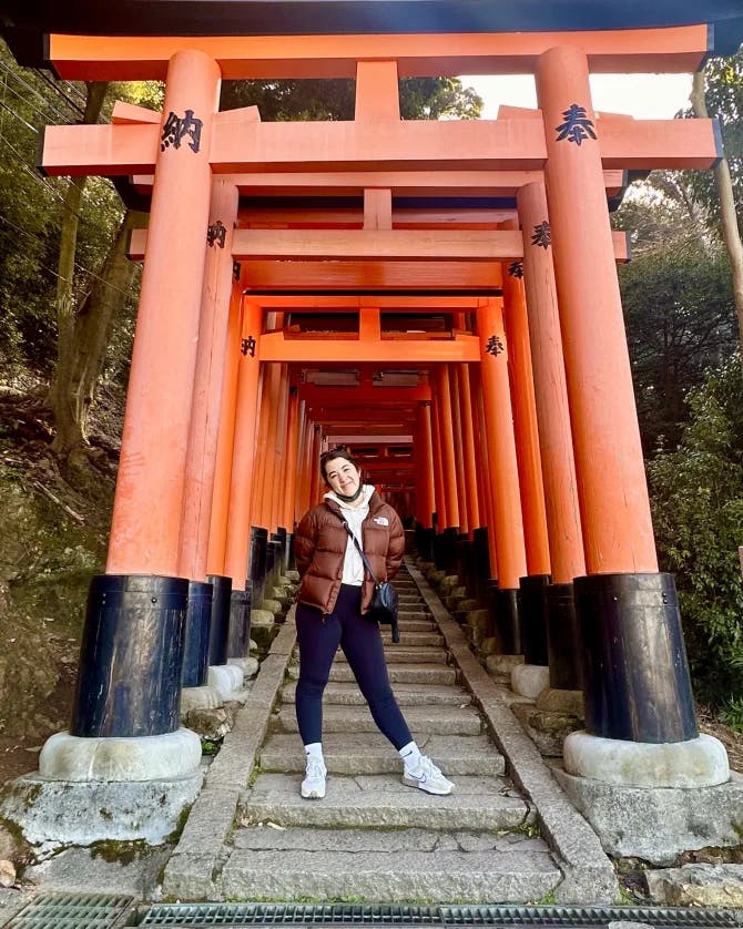 Marissa Morrill stands under a line of red Japanese gates
