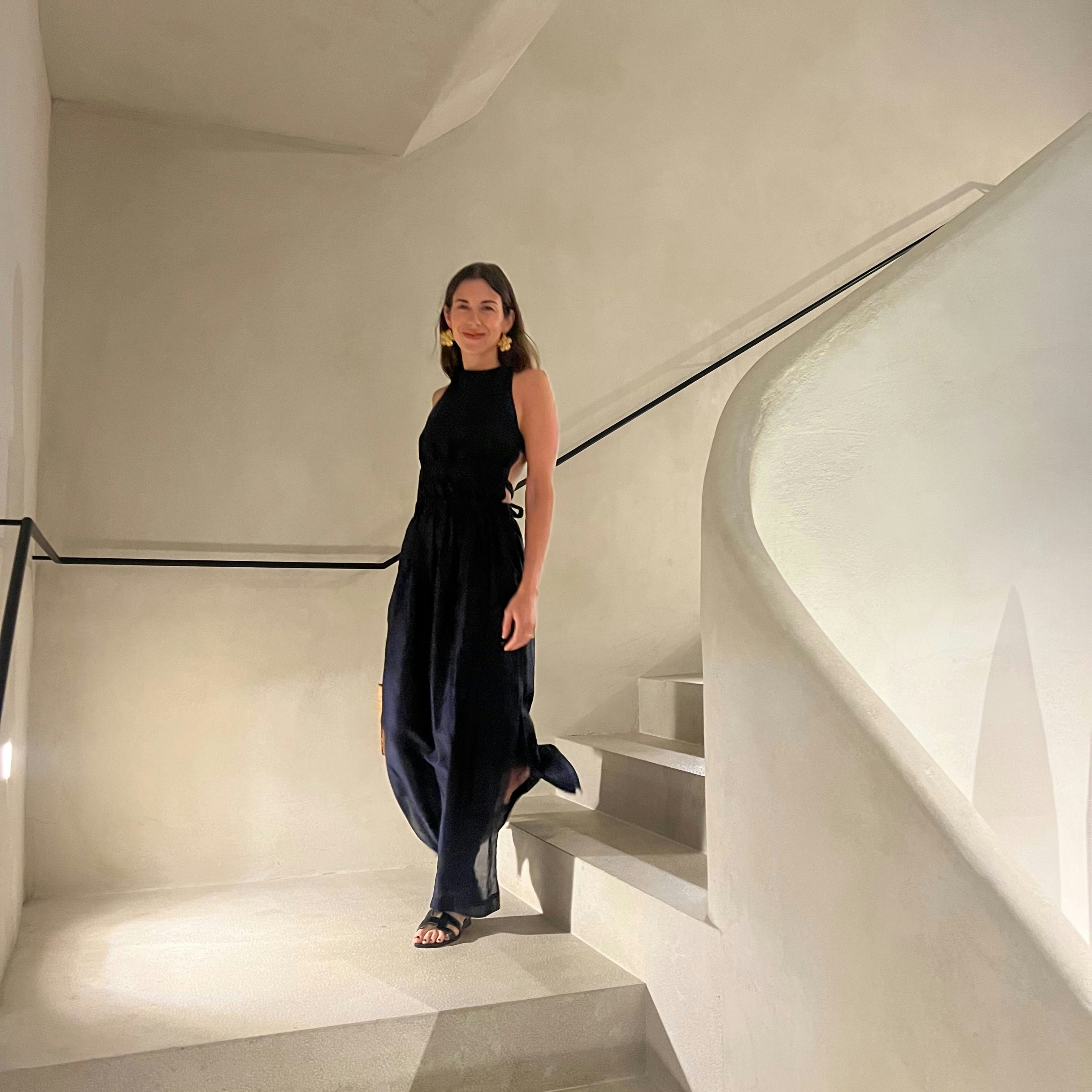 Travel Advisor Zoe Fisher in an all-black outfit standing on stairs