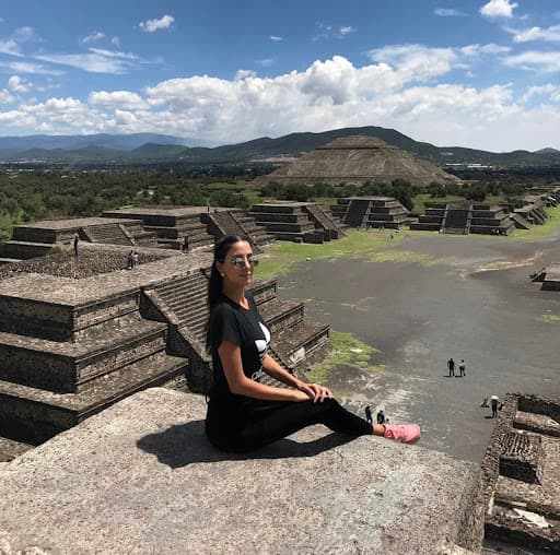 Girl sitting on a pyramid in Mexico.