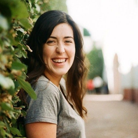 Travel Advisor Bree Smith smiles next to an ivy wall.
