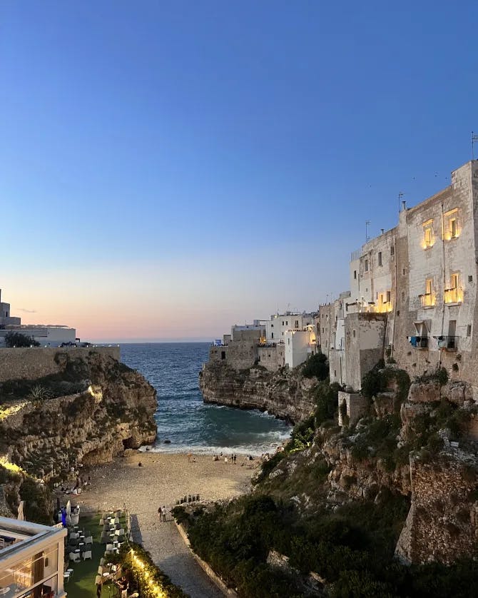 Picture of a beautiful sea villa at dusk with buildings and rocky cliffs 