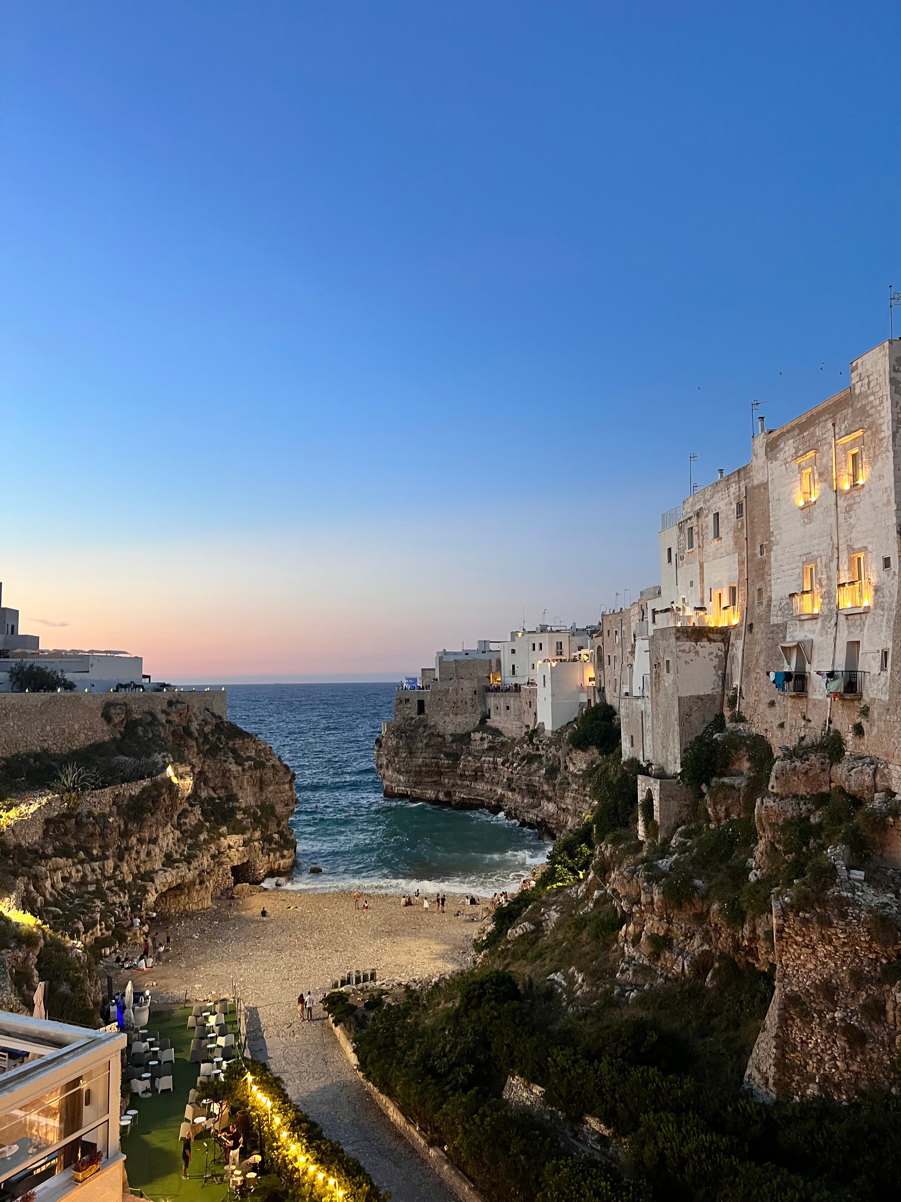 Picture of a beautiful sea villa at dusk with buildings and rocky cliffs