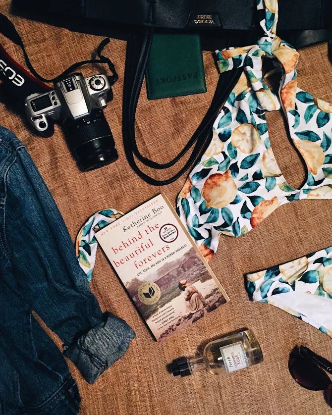 A book, bikini and a camera on the table