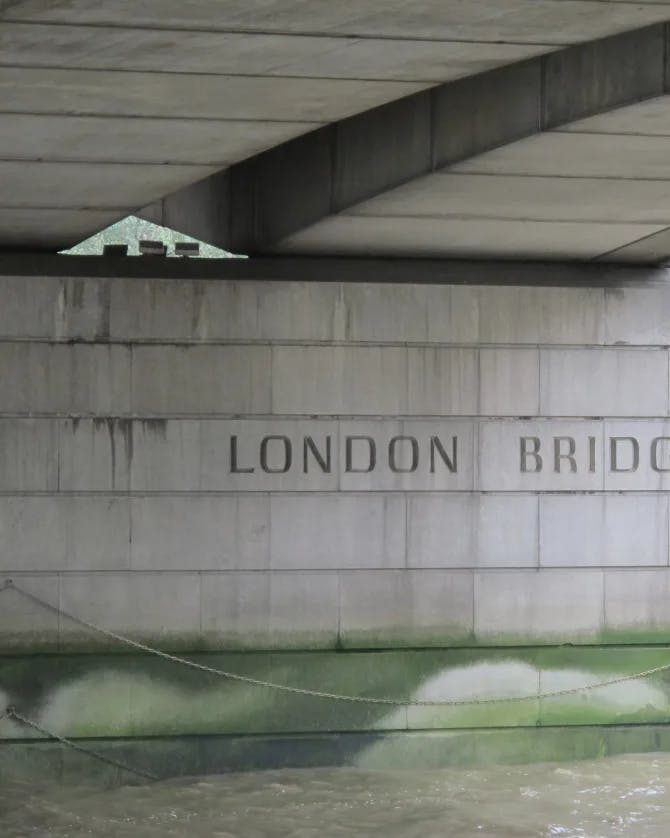 A view of the London Bridge from underneath with water damage showing on the stone