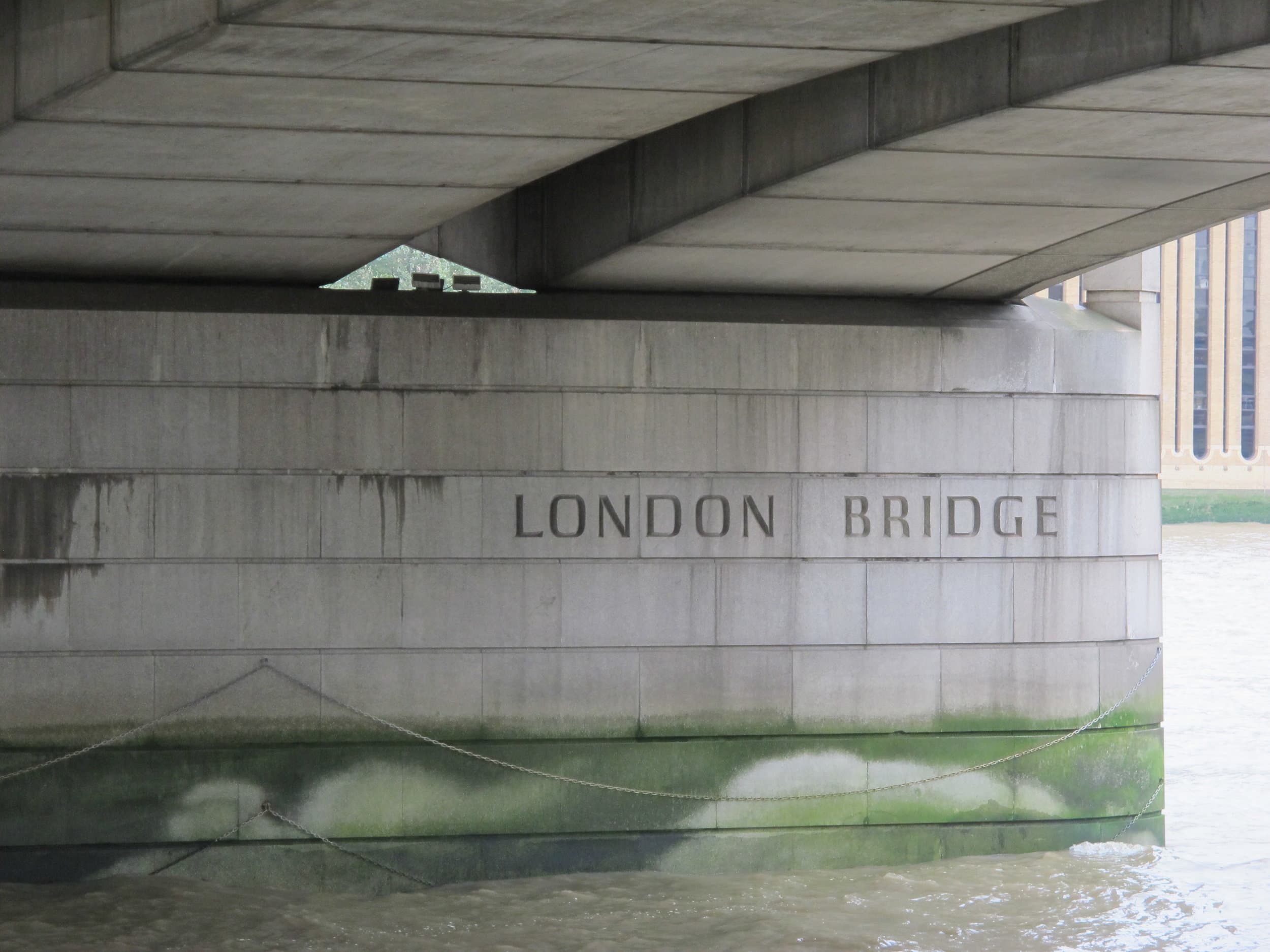A view of the London Bridge from underneath with water damage showing on the stone