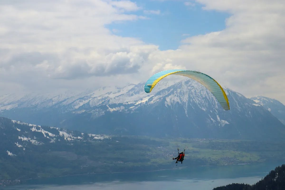 A person paragliding through the mountains during the daytime