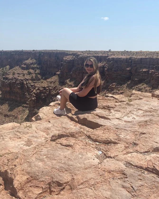 Picture of Juanita sitting on the edge of a cliff at the Grand Canyon