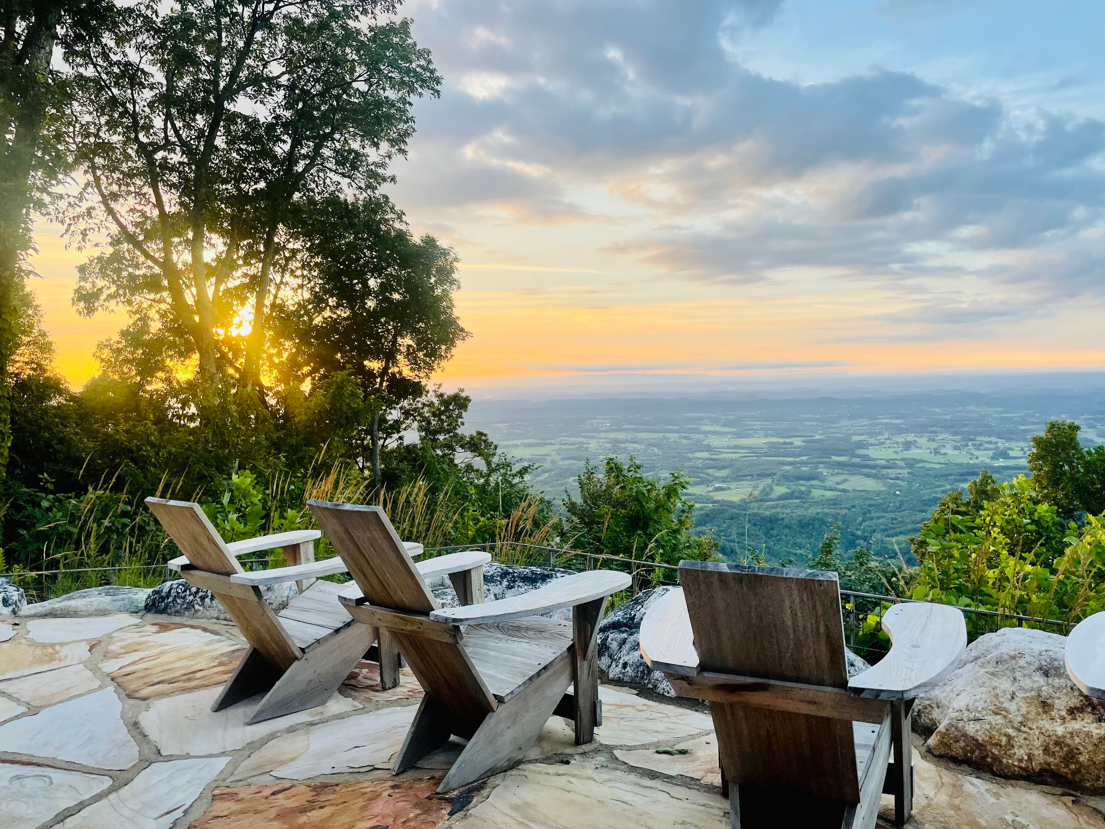 Three wooden chairs looking out to a landscape view and sunset from Blackberry Mountain Resort