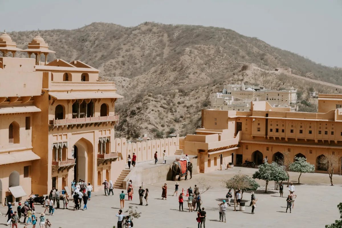 a palace entrance in a desert with mountains in the distance