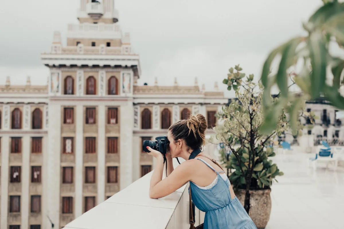 A woman with a professional camera takes pictures somewhere in Downtown Havana, Cuba (photo by Persnickety Prints)