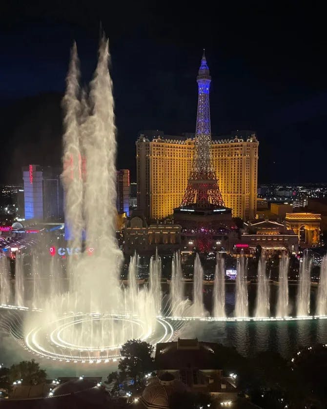 A nighttime view of a water show over the Las Vegas skyline