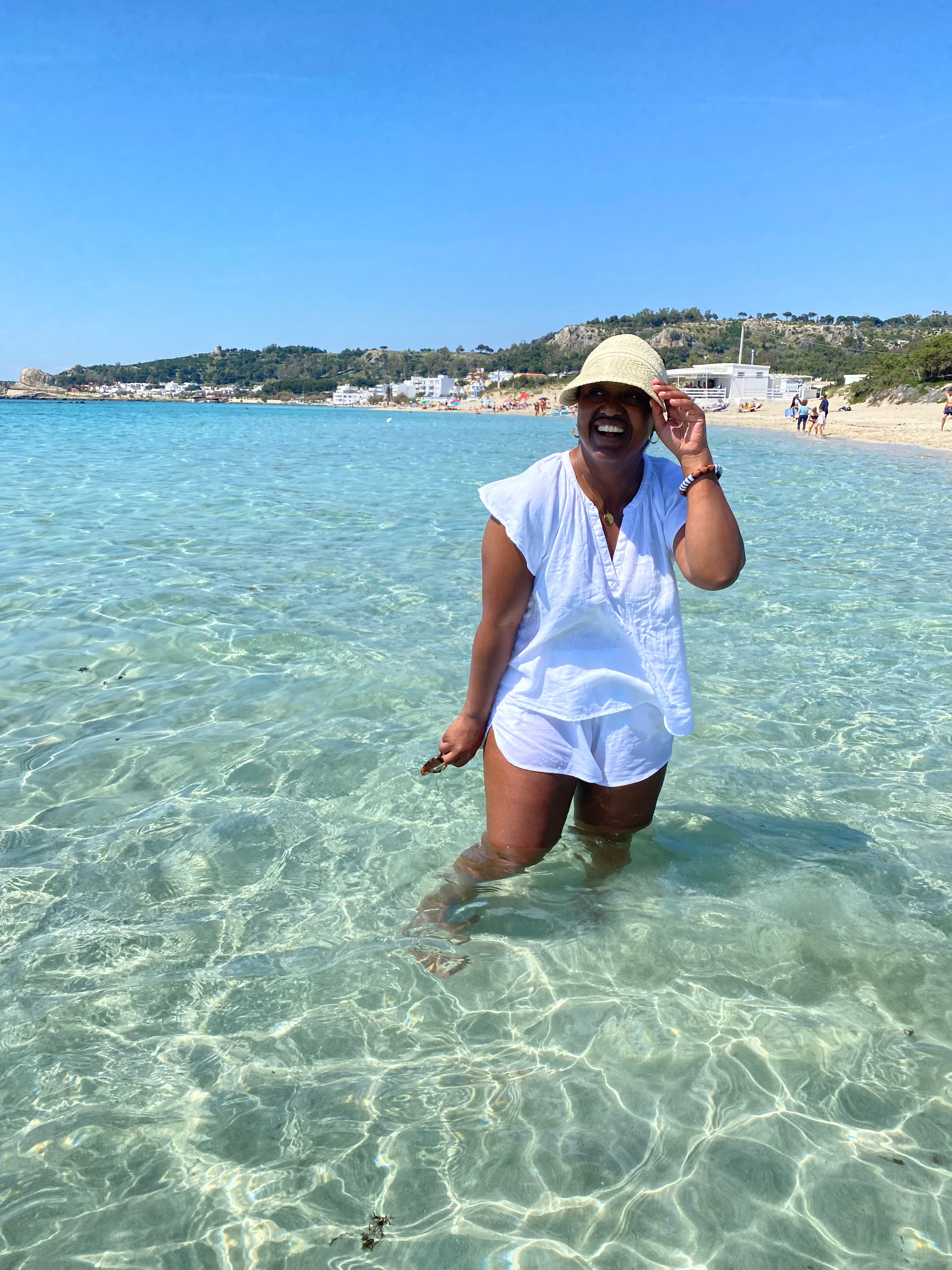 Girl standing in blue water in Greece.
