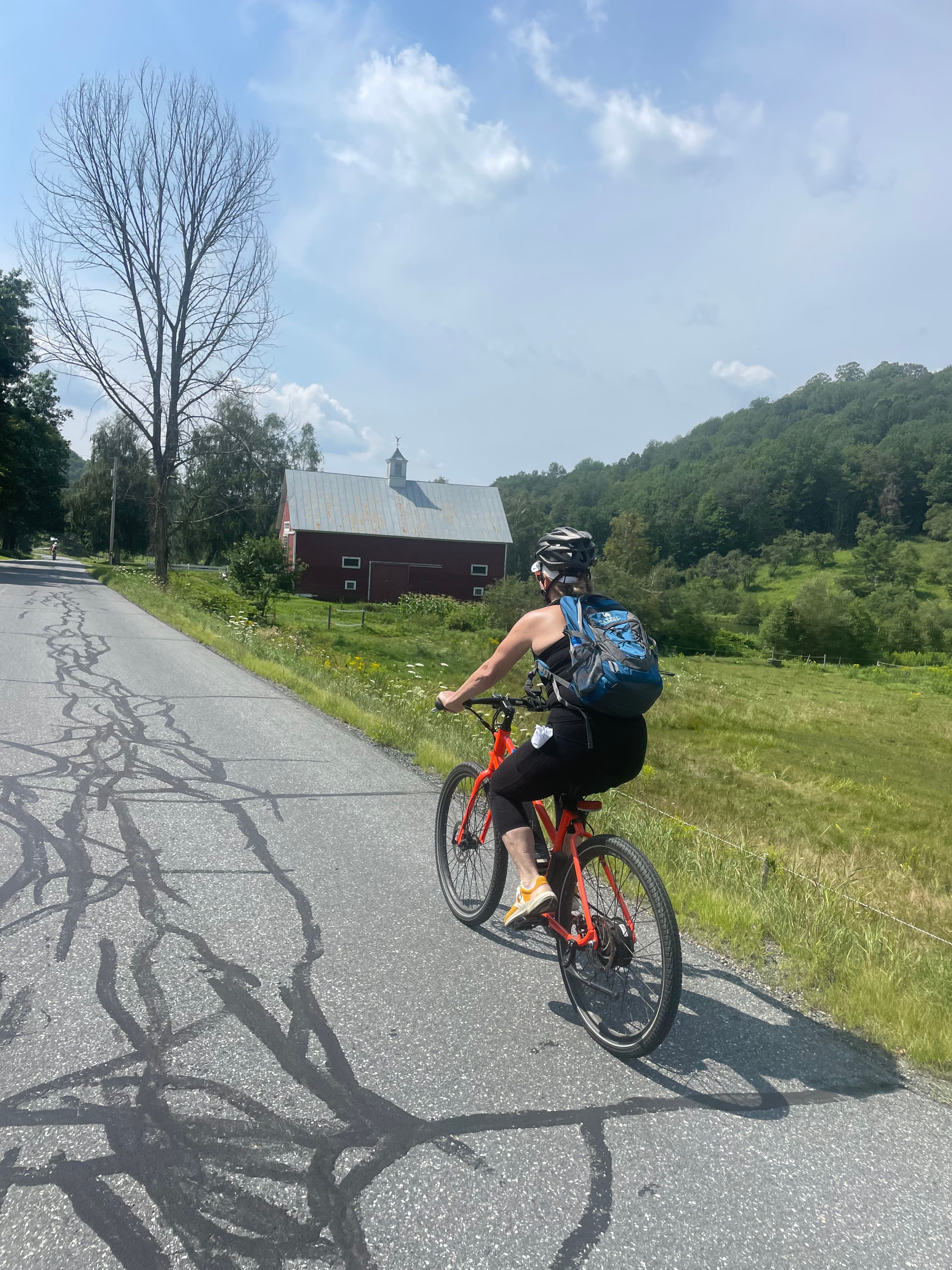 Advisor Kim Richter biking on the road along green grounds