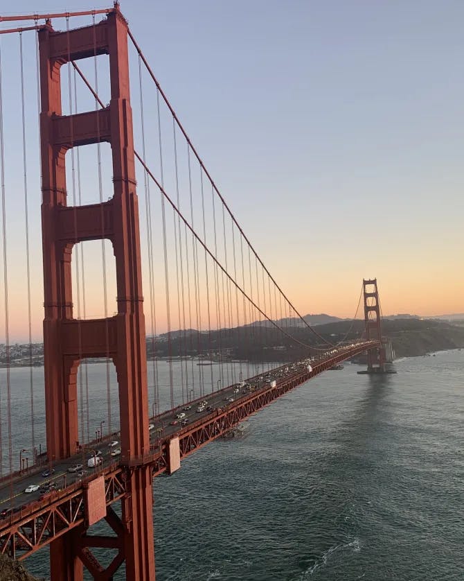 A view of the Golden Gate Bridge at sunset surrounded by water