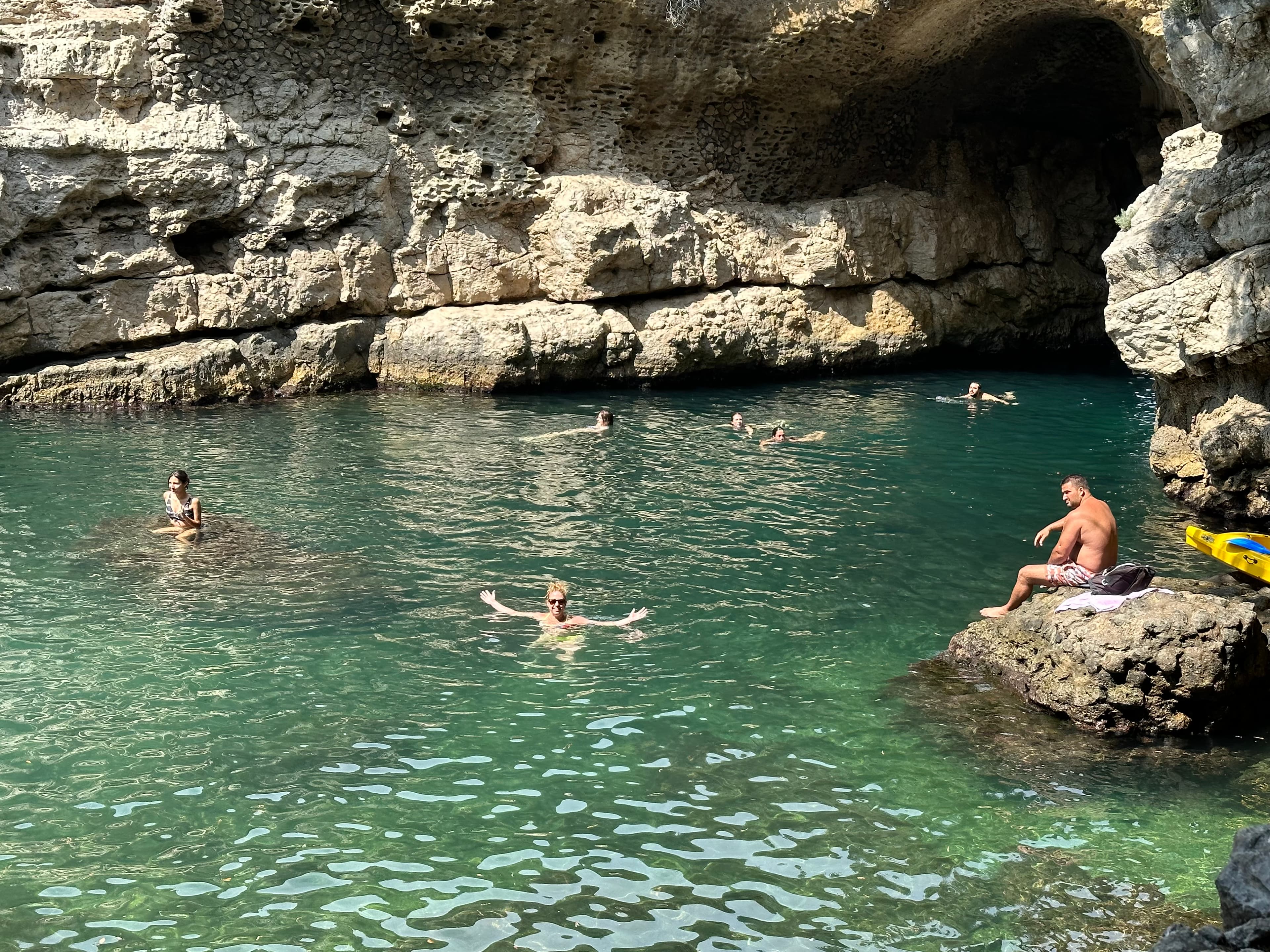 People swimming in the coves and caves of Bagni Regina Giovanna in Sorrento, Italy.