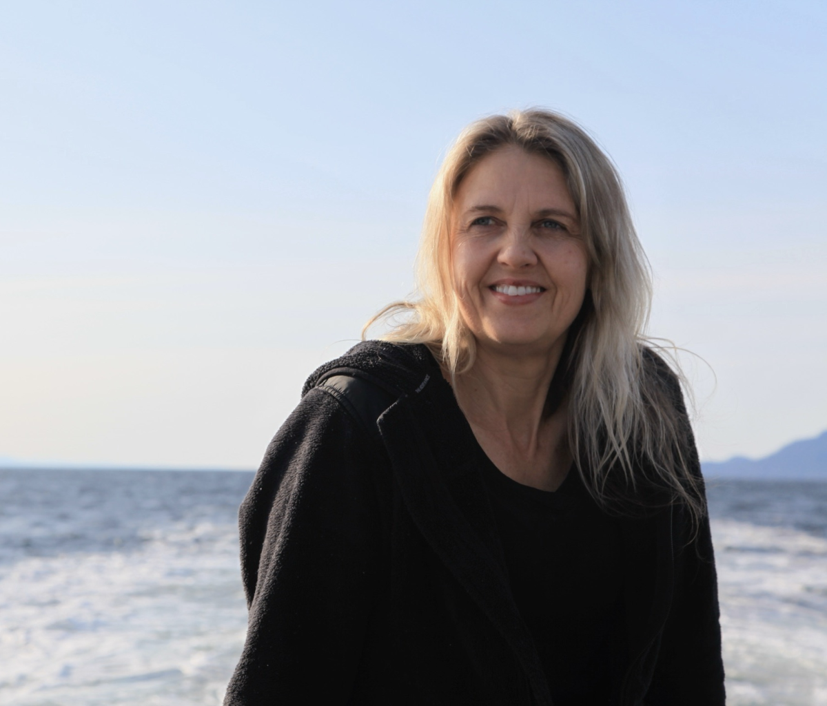 travel advisor Susan Anderson in a black sweatshirt on a beach